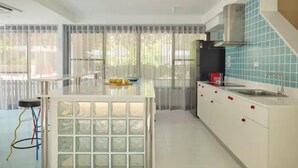Een moderne keuken met een centraal eiland, een ingebouwde kookplaat en een roestvrijstalen afzuigkap.