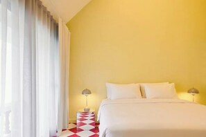 Une chambre d’hôtel avec un lit, deux lampes de chevet, une table de nuit et une fenêtre avec des rideaux.