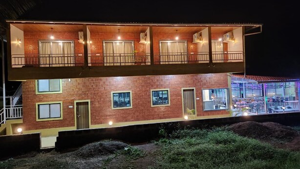 Un edificio de dos plantas con fachada de ladrillo, varias ventanas y un balcón.