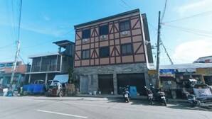 A multi-story building with a commercial ground floor and residential upper floors. - Skybox Pension House by RedDoorz (Iloilo City)