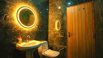 Een badkamer met een wastafel, spiegel, toilet en houten deur.