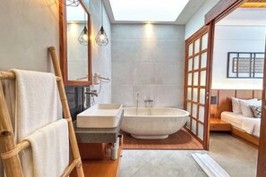 Een badkamer met een bad, een wastafel en een houten ladder.