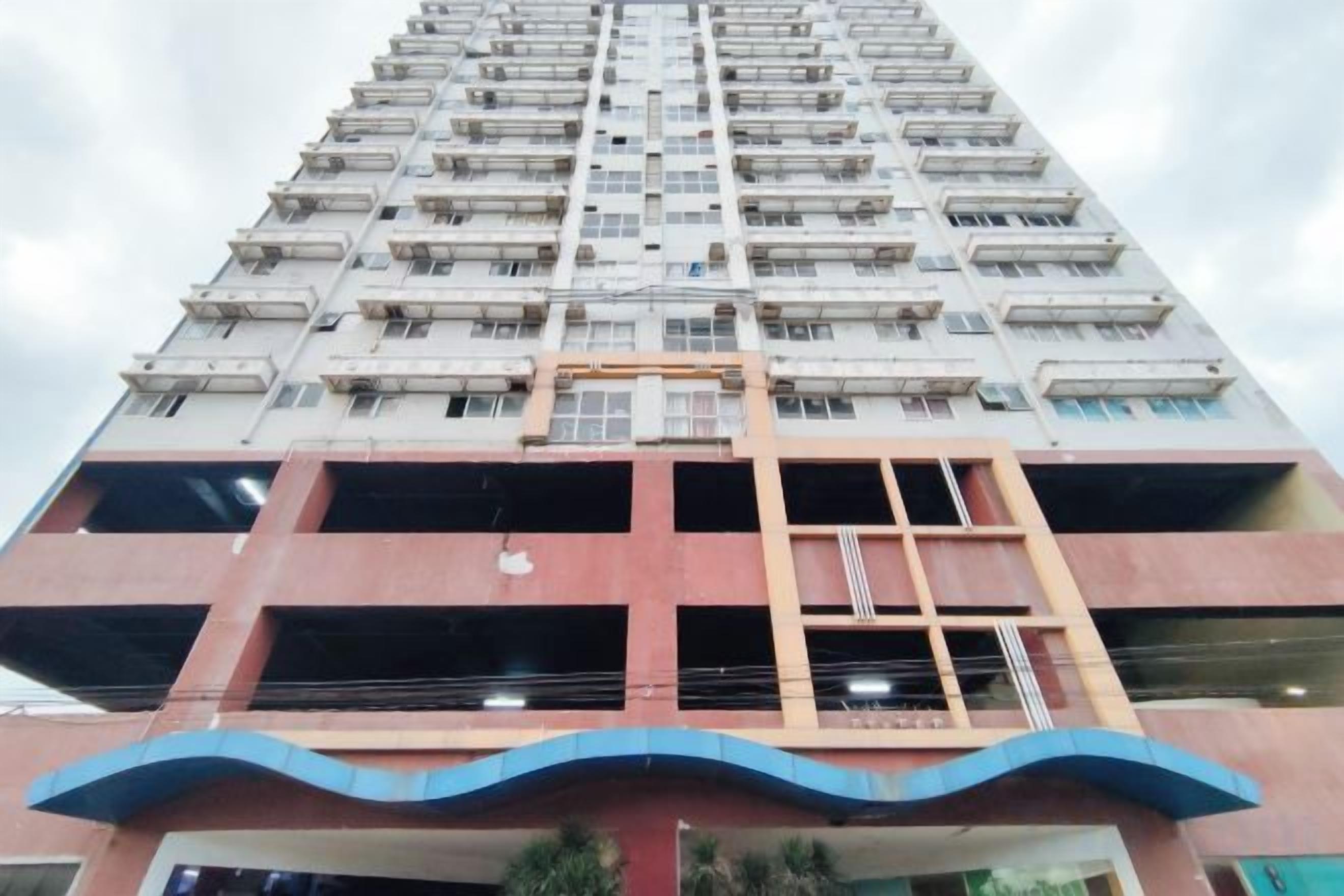 A high-rise building with multiple floors, balconies, and a central staircase.