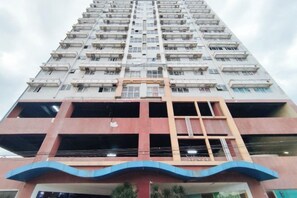 A high-rise building with multiple floors, balconies, and a central staircase. - San Marino JY7 Rentals by RedDoorz (Cebu City)
