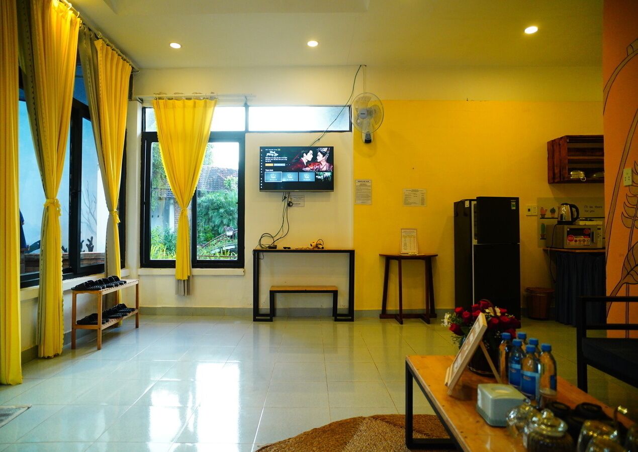 Una sala de estar con televisor, cafetera y mesa de comedor.