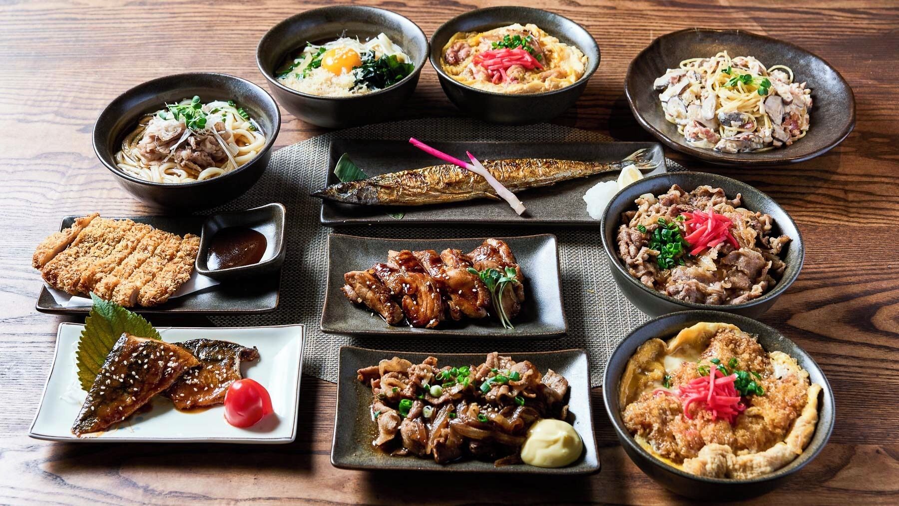 A variety of Japanese dishes arranged on a wooden table.