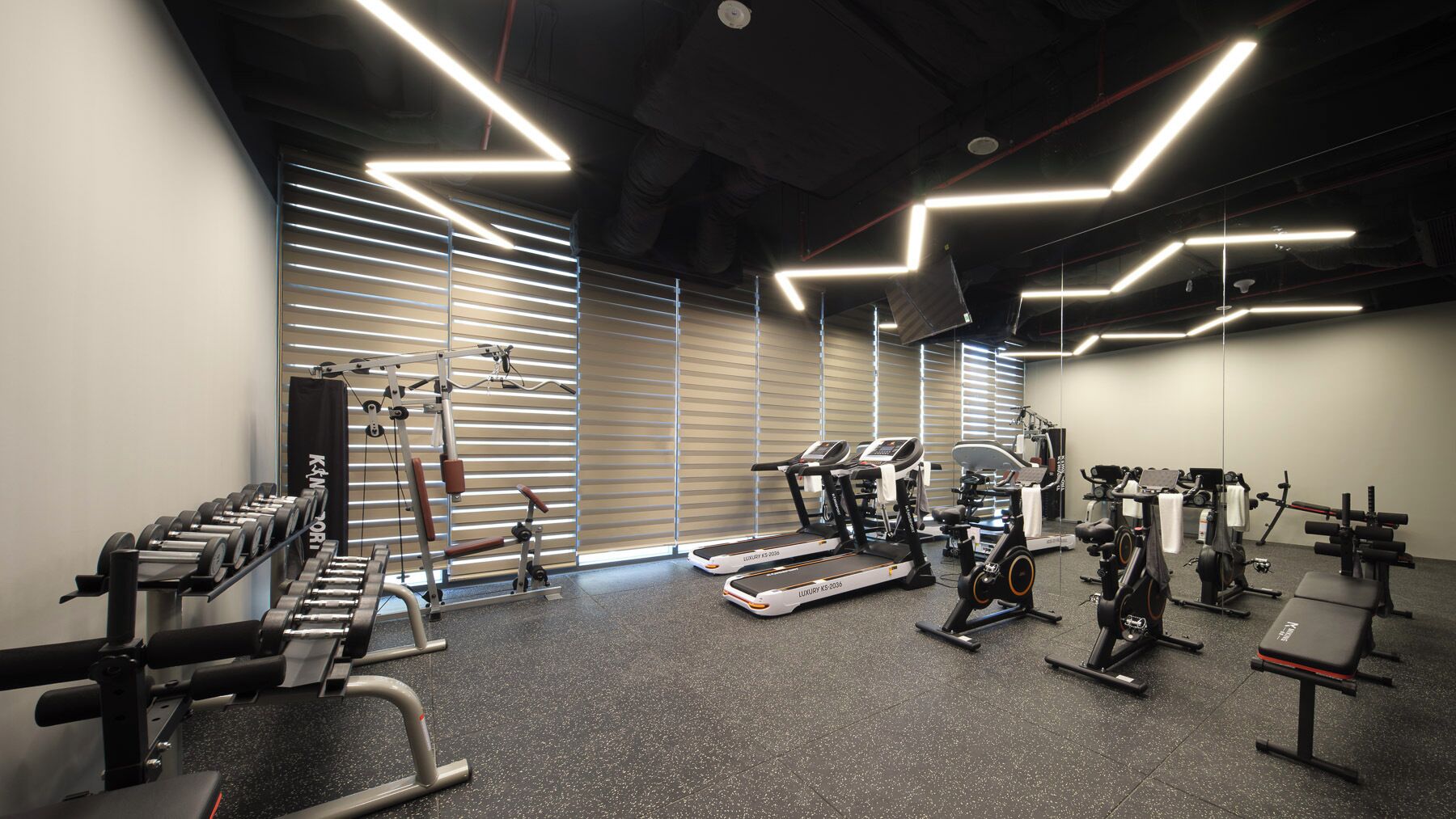 Et fitnesscenter med træningsudstyr, løbebånd og styrkemaskiner.