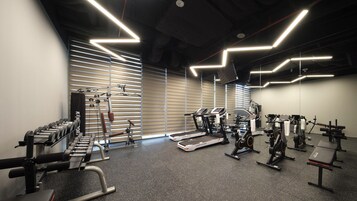 Une salle de sport équipée de matériel d’exercice, de tapis de course et d’appareils de musculation.