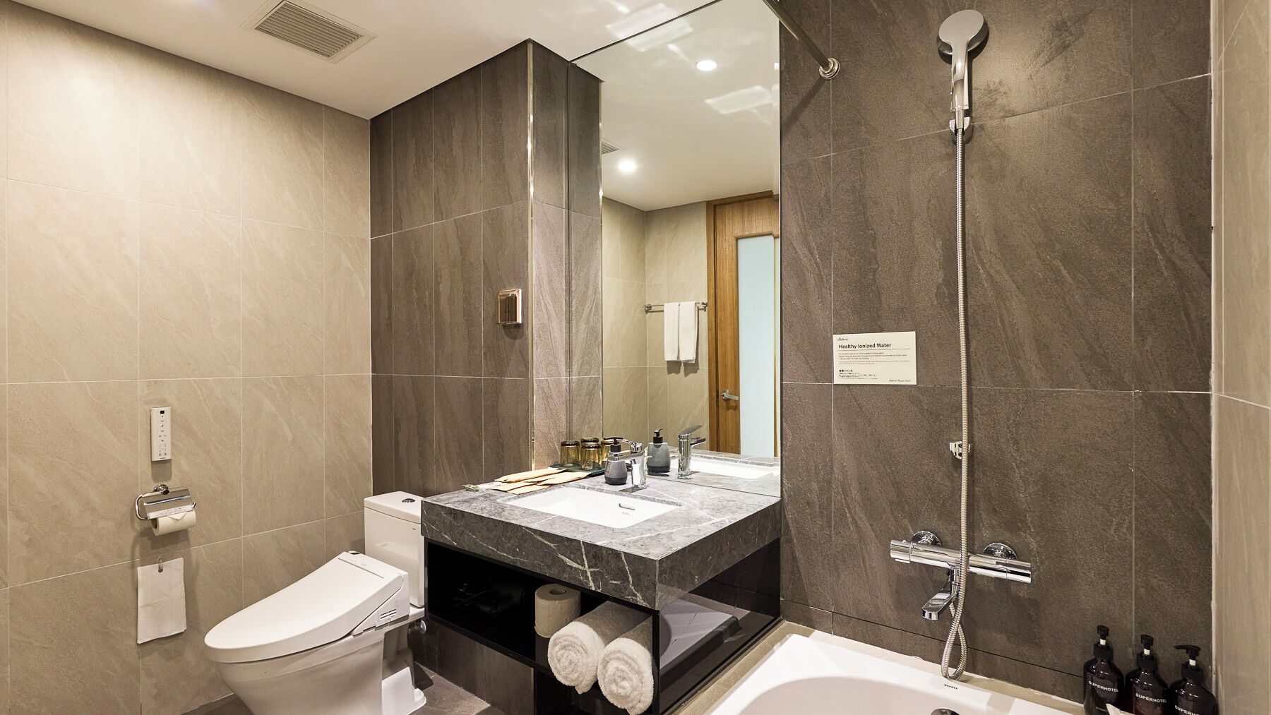 A modern bathroom with a toilet, sink, and shower.