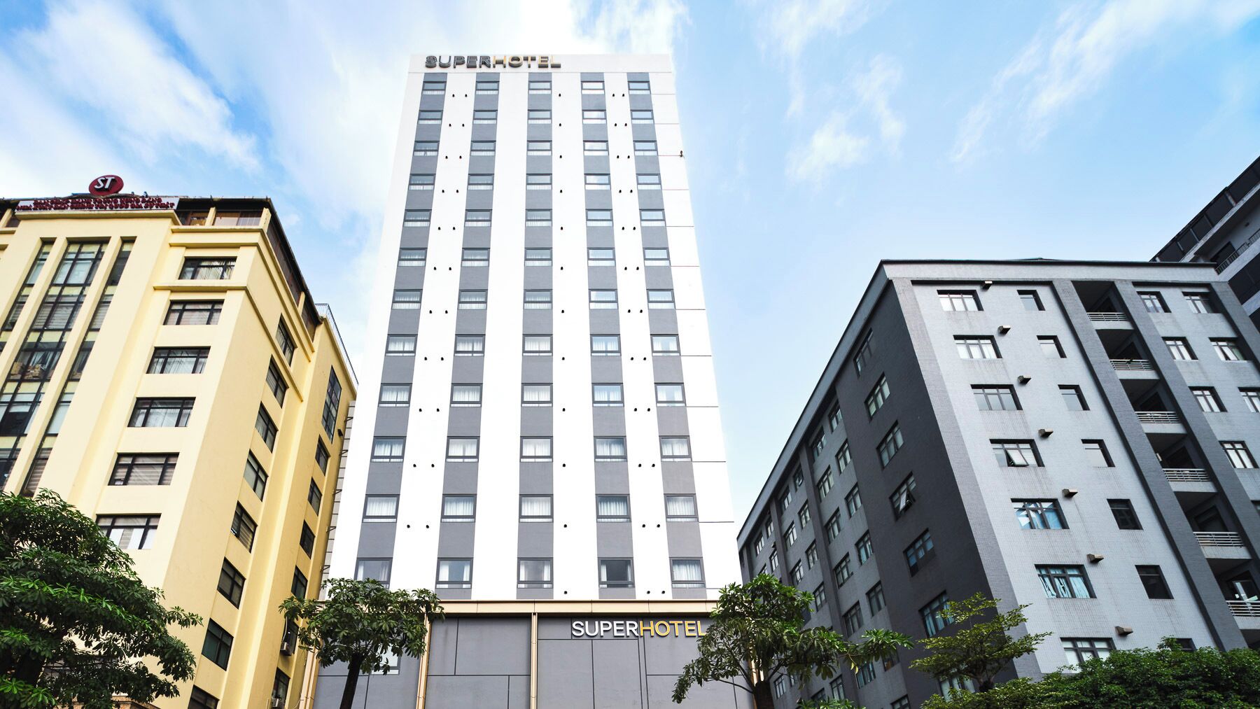 Edificio de SuperHotel con diseño moderno, destacando una fachada vertical con ventanas uniformemente espaciadas.
