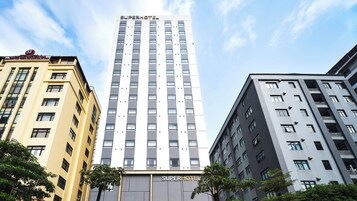 A SuperHotel building with a modern design, featuring a prominent vertical facade with evenly spaced windows.