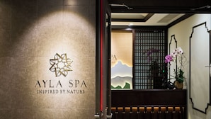 L’entrée d’un spa, avec un logo, un comptoir d’accueil et une vue sur une montagne par une fenêtre.