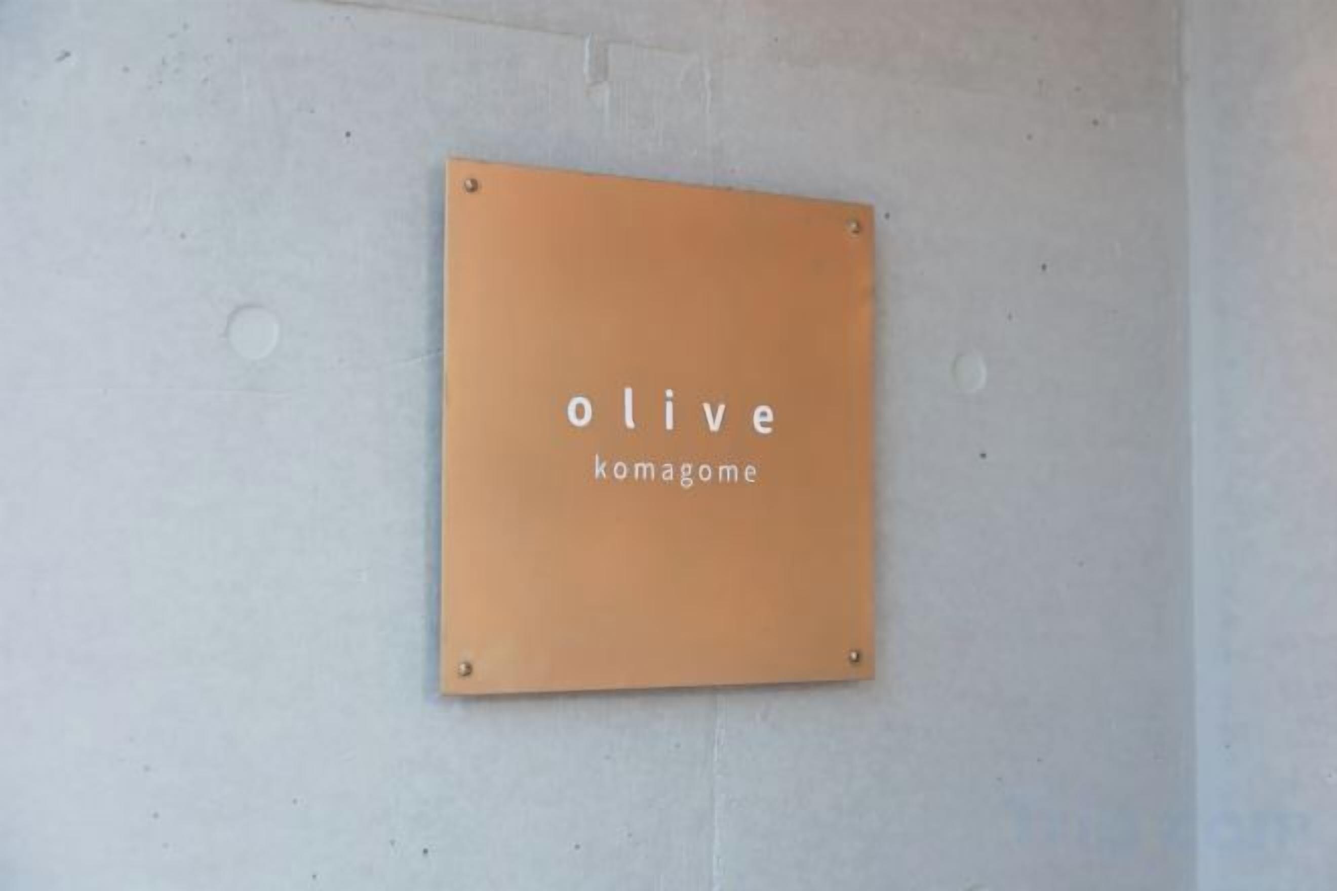 Een bord aan de muur met de tekst 'olive komagome'.