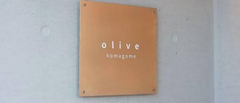 Een bord aan de muur met de tekst 'olive komagome'.