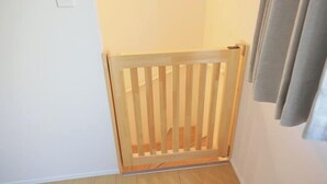 Une pièce avec une porte en bois, un interrupteur sur le mur et un rideau sur le côté droit.