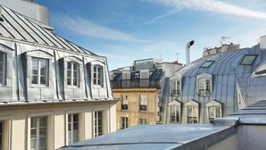 A row of historic buildings with classic European architecture, featuring prominent gabled roofs and symmetrical window designs.