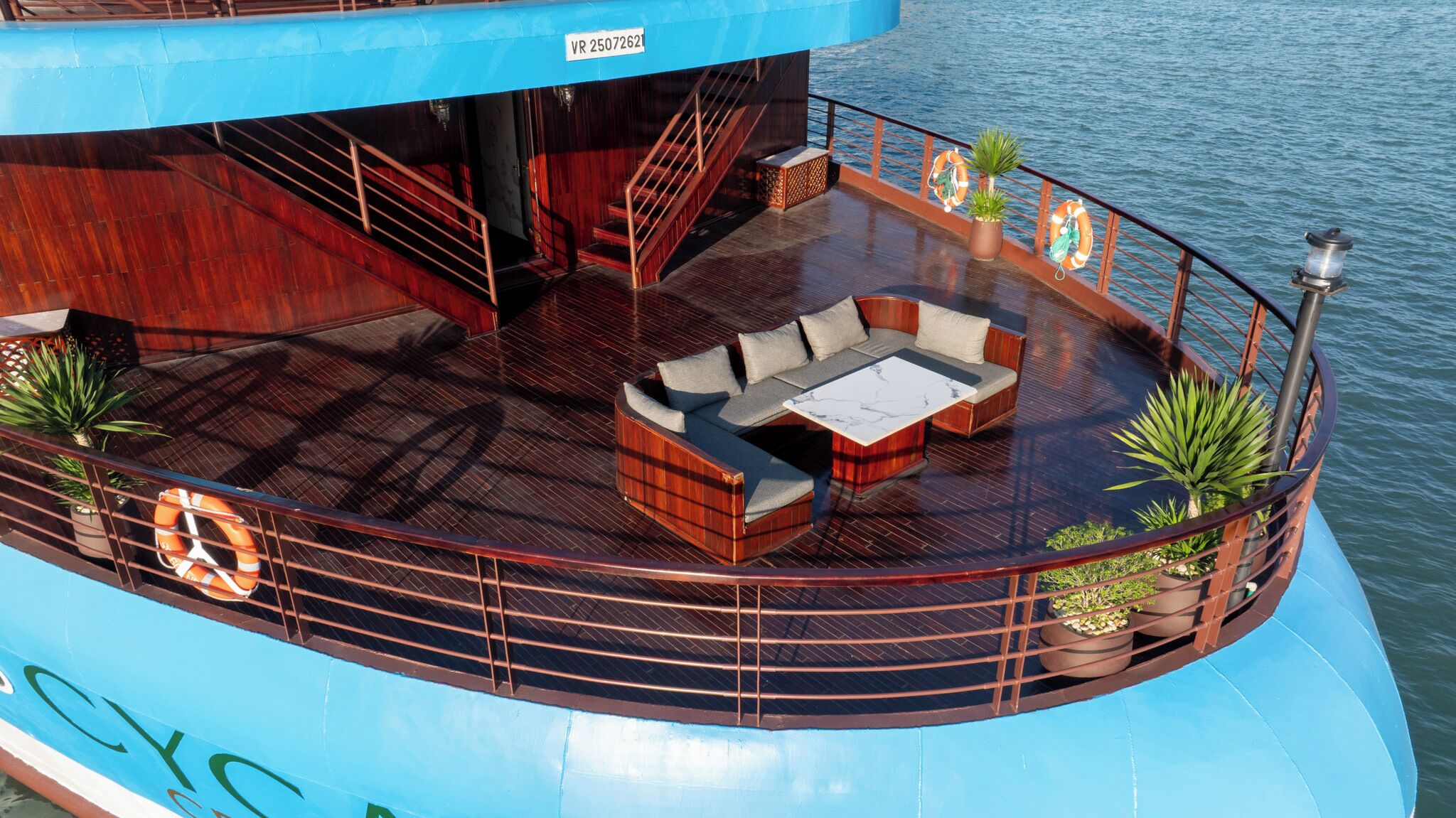 A deck with a sofa set, a coffee table, and potted plants.