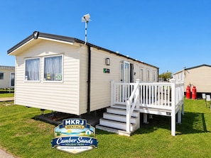 A single-story mobile home with a front porch and a small deck.