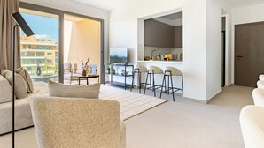 Une chambre d’hôtel moderne comprenant un espace de vie, un coin repas et une cuisine.
