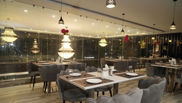 En moderne restaurant med et aflangt spiseområde, flere borde og stole.
