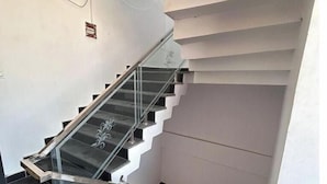 En moderne trappe med glasgelændere og gelænder, der fører op til en platform.