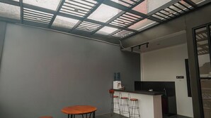 Un interior moderno con tragaluces, mesas redondas y una zona de bar.