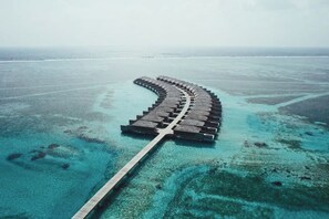 A long, straight pathway leading through a clear blue sea, surrounded by a flat, open landscape. - Jawakara Islands Maldives (Maabinhuraa)