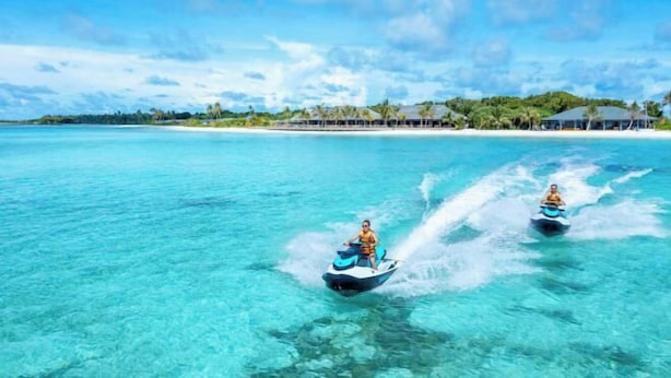Two jet skis on a clear turquoise sea with a beach and resort buildings in the background. - Jawakara Islands Maldives (Maabinhuraa)