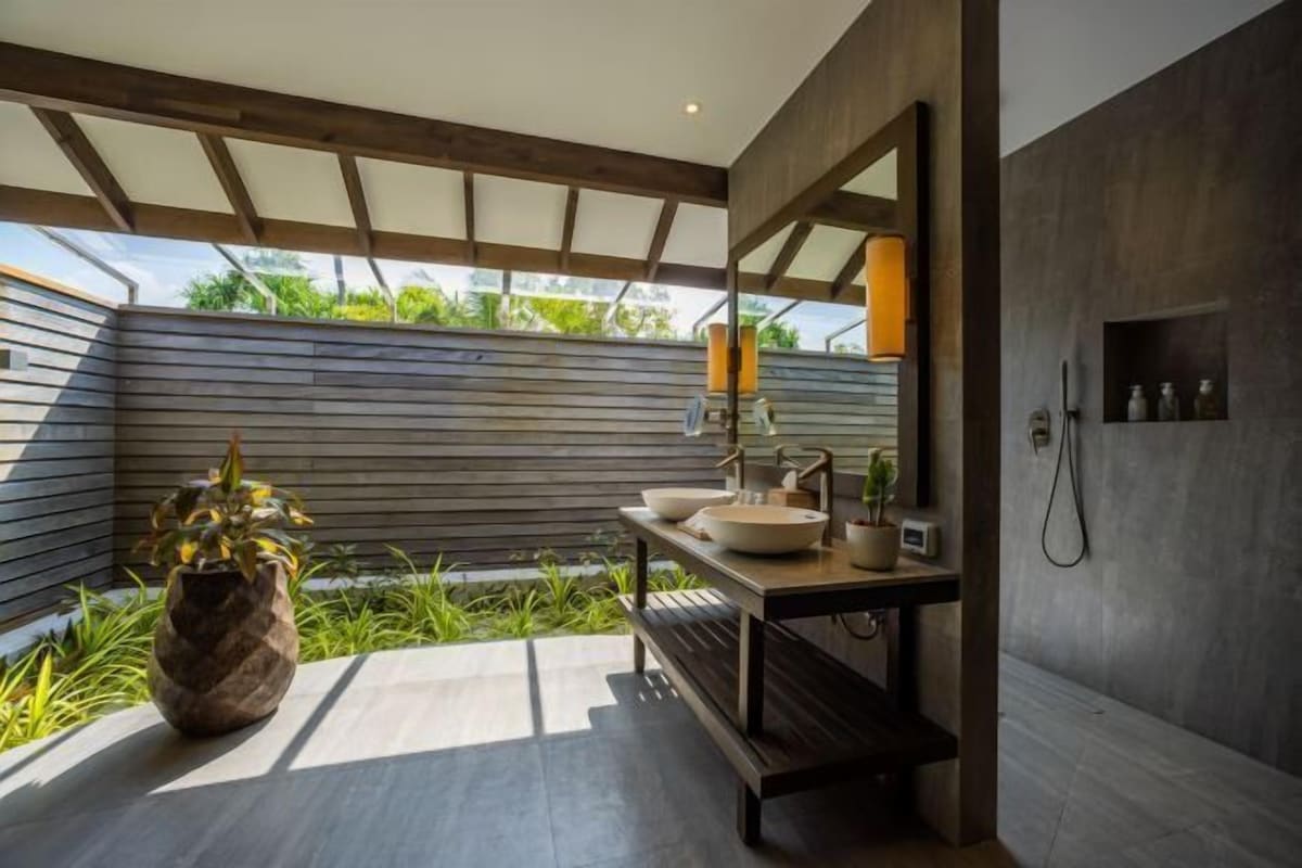Une salle de bain moderne avec un meuble-lavabo en bois, un grand miroir et un espace douche.