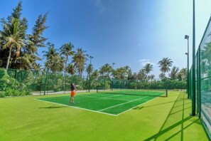 A tennis court with a net, surrounded by a fence and palm trees. - Jawakara Islands Maldives (Maabinhuraa)
