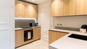 Een moderne keuken met houten kastjes, een magnetron en een koffieapparaat.