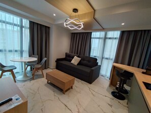 Apartamento Deluxe | Zona de estar | Smart TV de 50 pulgadas con canales digitales