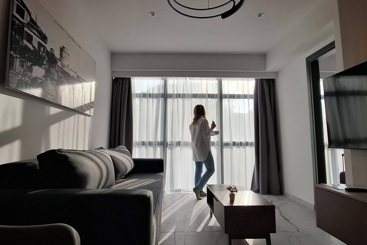 Ein modernes Wohnzimmer mit einer Couch, einem Couchtisch und einem Fernseher.