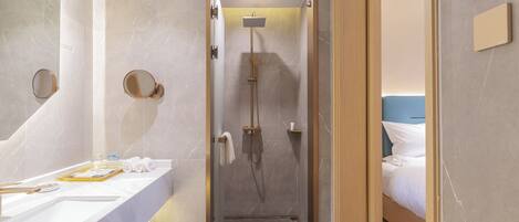 A modern bathroom with a shower, a sink, and a mirror.