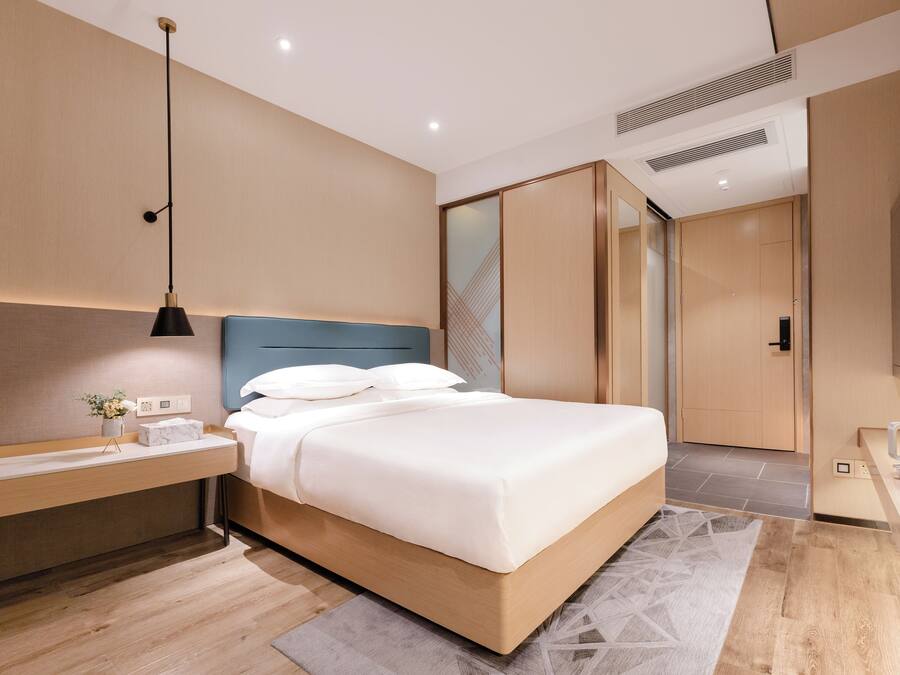 A modern bedroom with a bed, bedside table, and a built-in wardrobe.