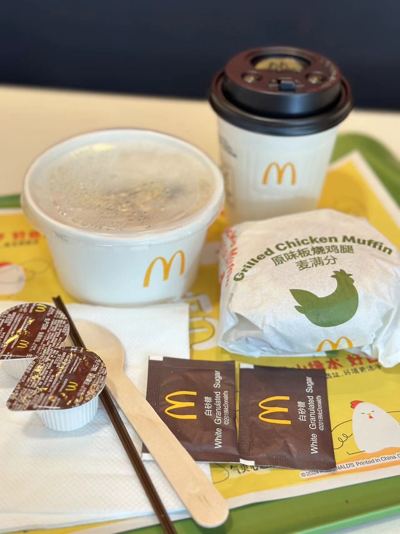 Ein McDonald's Menü mit einem Getränk, einem Hühnchen-Muffin und einem Beutel feinem Zucker.