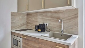 Una cocina con dos fregaderos, un microondas y una cafetera.
