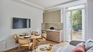 Una cocina moderna con comedor, sofá y televisor montado en la pared.