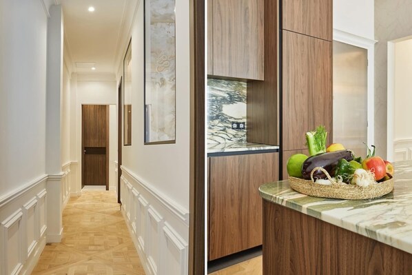 A hallway with a wooden floor and a door at the end.