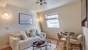 Una sala de estar moderna con sofá, mesa de centro y comedor.