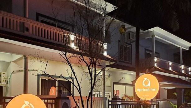 A two-story building with a sign for 'Apricot Inn' indicating a hotel. - Apricot Inn (Morjim)