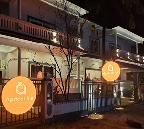 Ein zweistöckiges Gebäude mit einem Schild, das 'Apricot Inn' als Hotel kennzeichnet.
