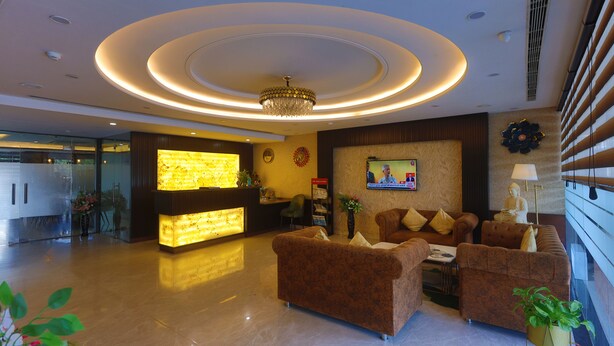 A modern lobby with a reception desk, sofas, and a chandelier. - HOTEL THE SAFFRON PARK (Panchkula)