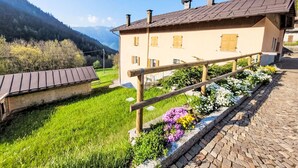 Un bâtiment doté d’un toit en pente, de volets en bois et d’un chemin en briques menant à l’entrée.