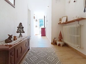 En hall med ett element, en mönstrad matta och dekorativa föremål, inklusive ett träd och en ren.