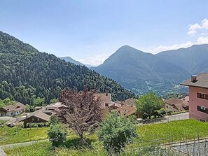 A rural village with houses, a tree, and mountains in the background. - Apartment Festér by Interhome (Ragoli)