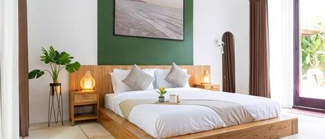A bedroom with a wooden bed, bedside lamps, a green accent wall, and a large window.