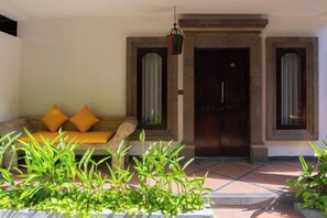 A room with a sofa, a door, and a window. - Purnava Village by Behomy (Bali)