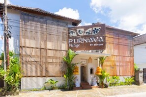 A building with a sign reading 'Purnava Village by Benyomi.' - Purnava Village by Behomy (Bali)