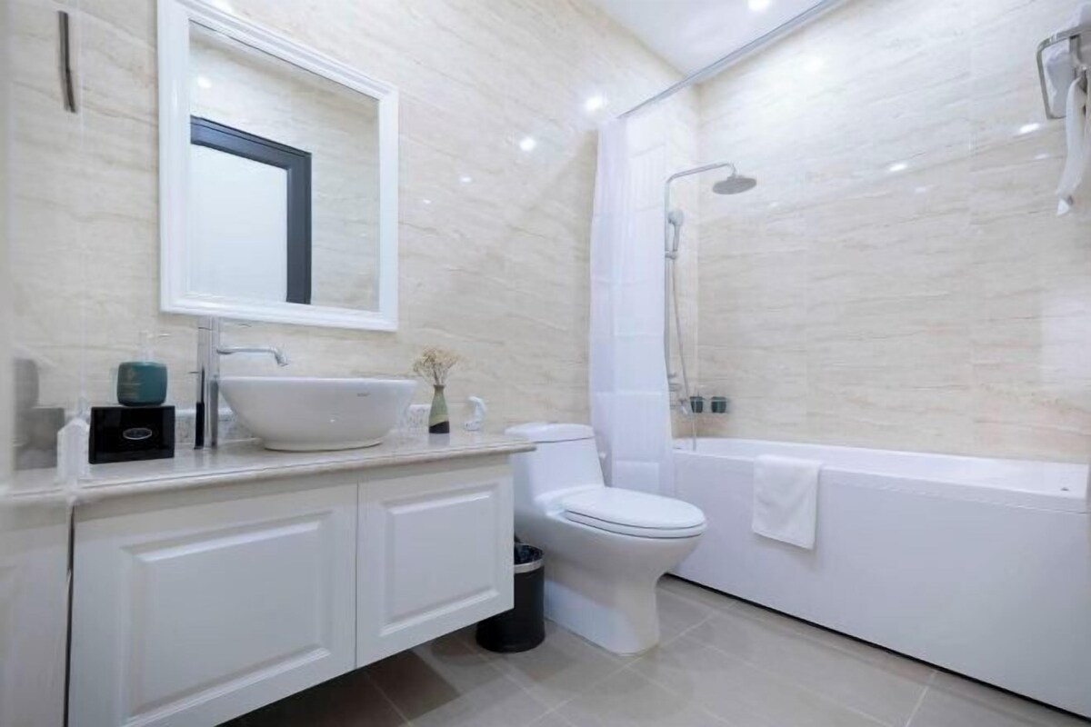 A modern bathroom with a sink, toilet, and bathtub.